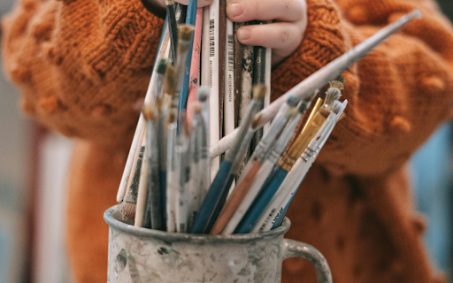 A Child Holding Paintbrushes in a Mug screenshot 1