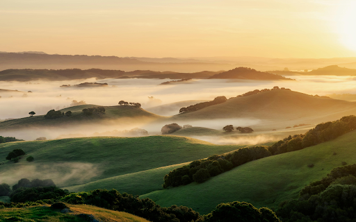 A sunrise over a valley with fog and hills screenshot 1