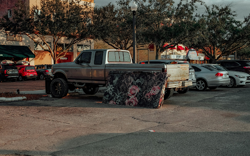 A truck parked in a parking lot with a mattress on the back screenshot 1