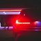 Car with Illuminated Tail Lights at Night logo