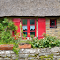 Thatched roof house and red door logo