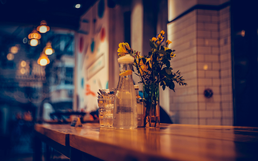 Water Beside Glass Vase with Yellow Flowers on a Wooden Surface screenshot 1